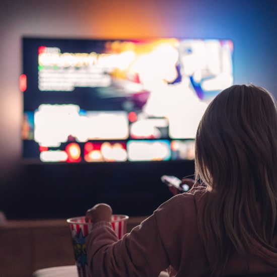 young-woman-watching-tv-and-eating-popcorn-at-night-picjumbo-com (1)